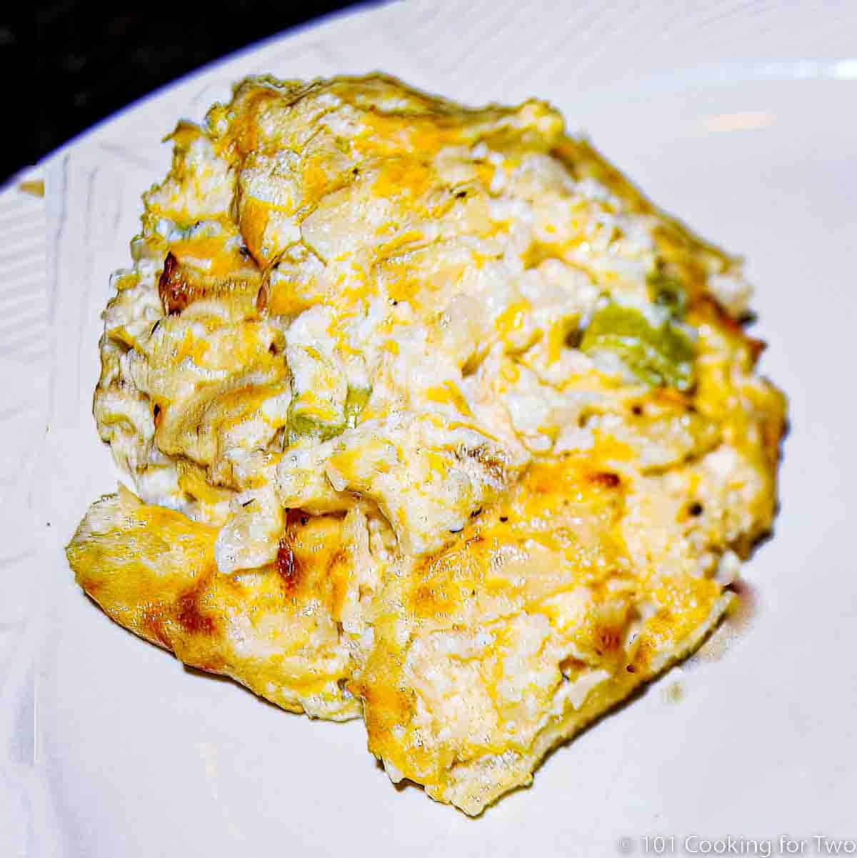cheesy cauliflower casserole on white plate