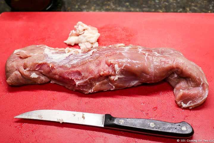 trimmed pork tenderloin on red board