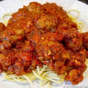 italian Sausage Marinara on pasta on a white plate