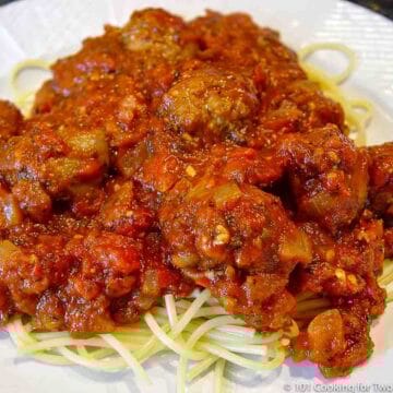 italian Sausage Marinara on pasta on a white plate