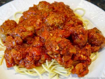 sausage marinara on pasta on a white plate