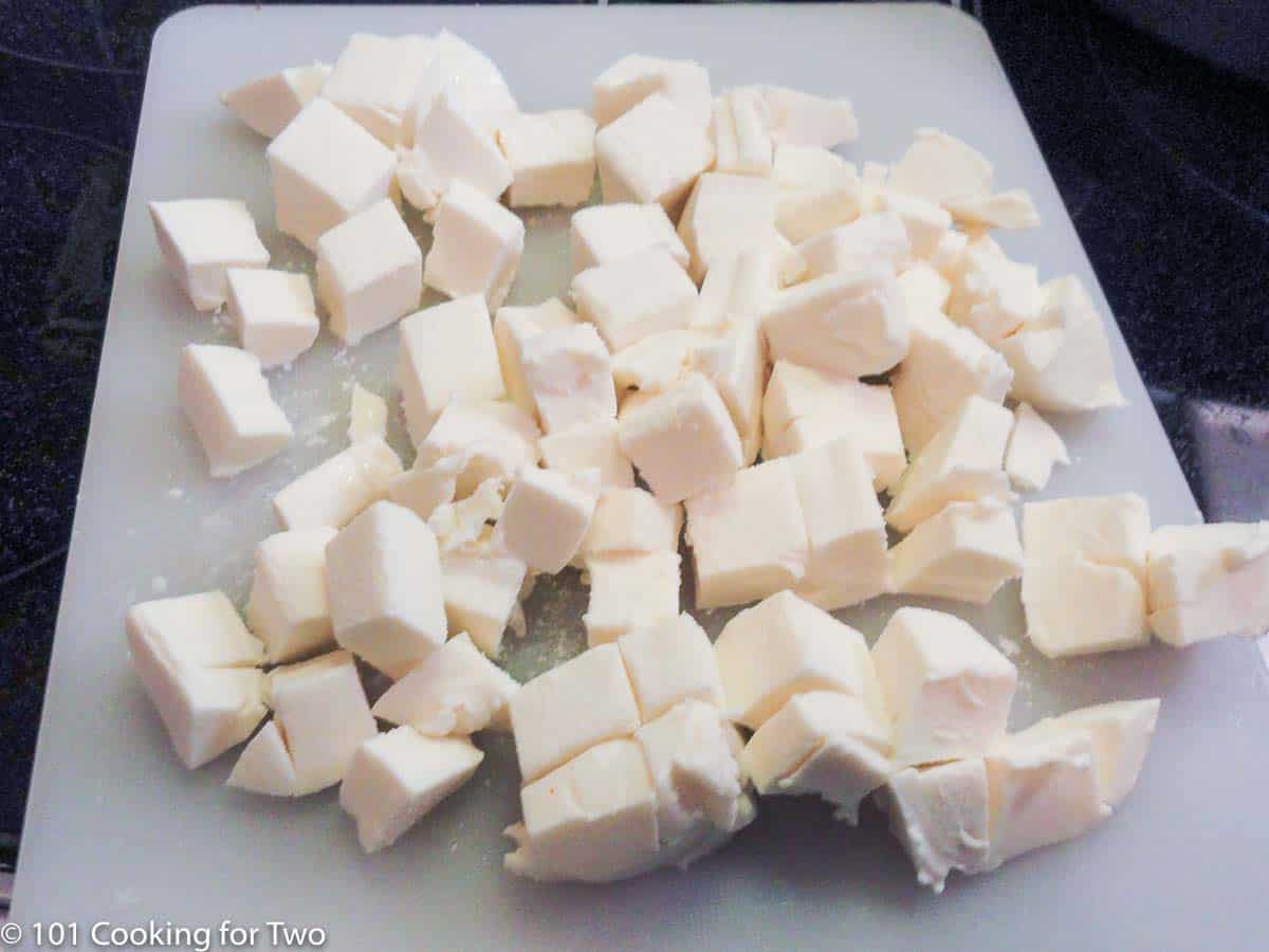 cubes of cheese on white board.