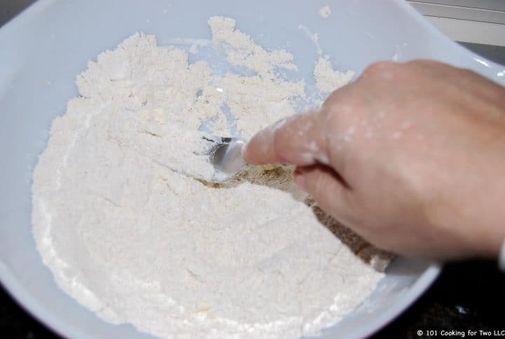 cutting butter into a bowl of flour with fork