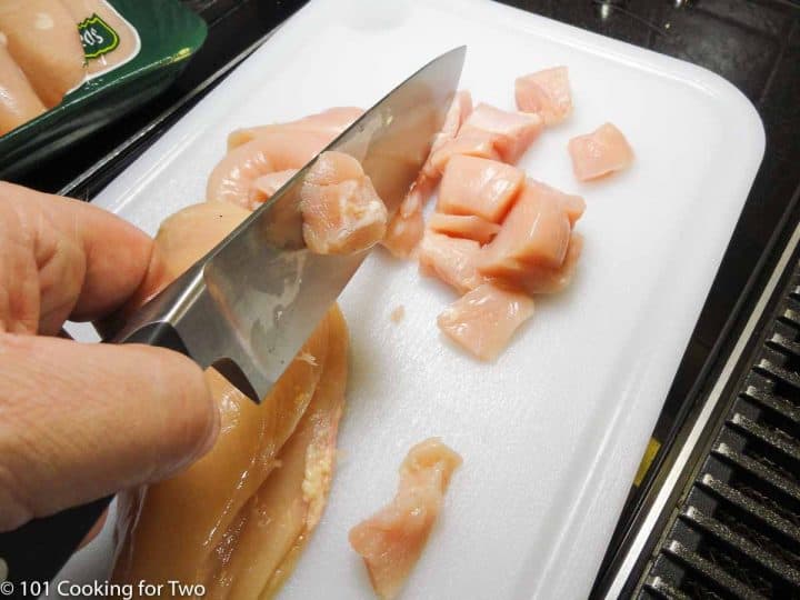 cutting skinless chicken into cubes