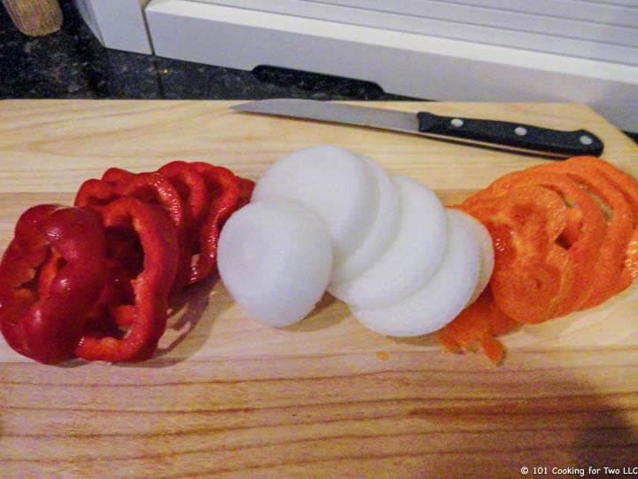 sliced peppers and onion on wood board.
