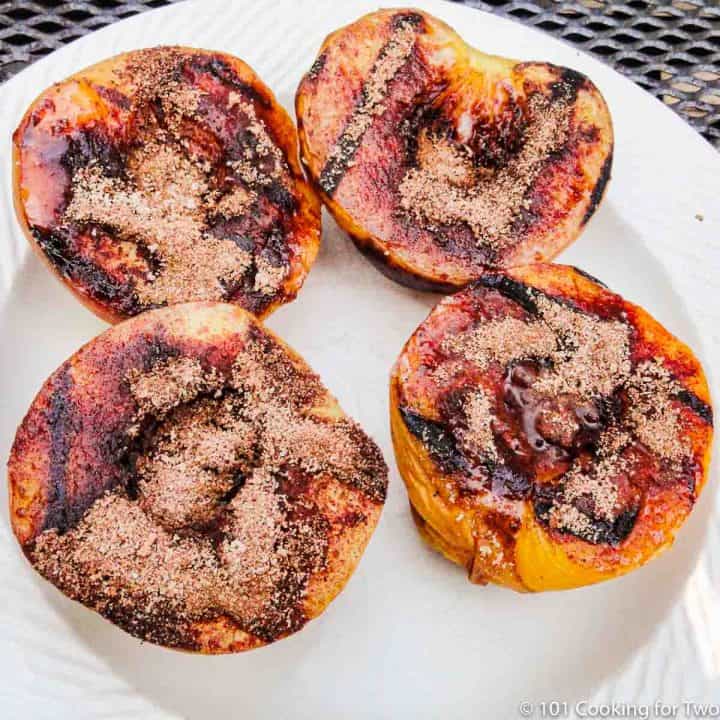 grilled peaches on a white plate