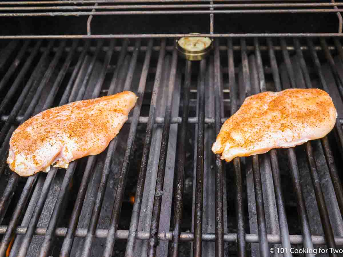 raw seasoned chicken on the grill.