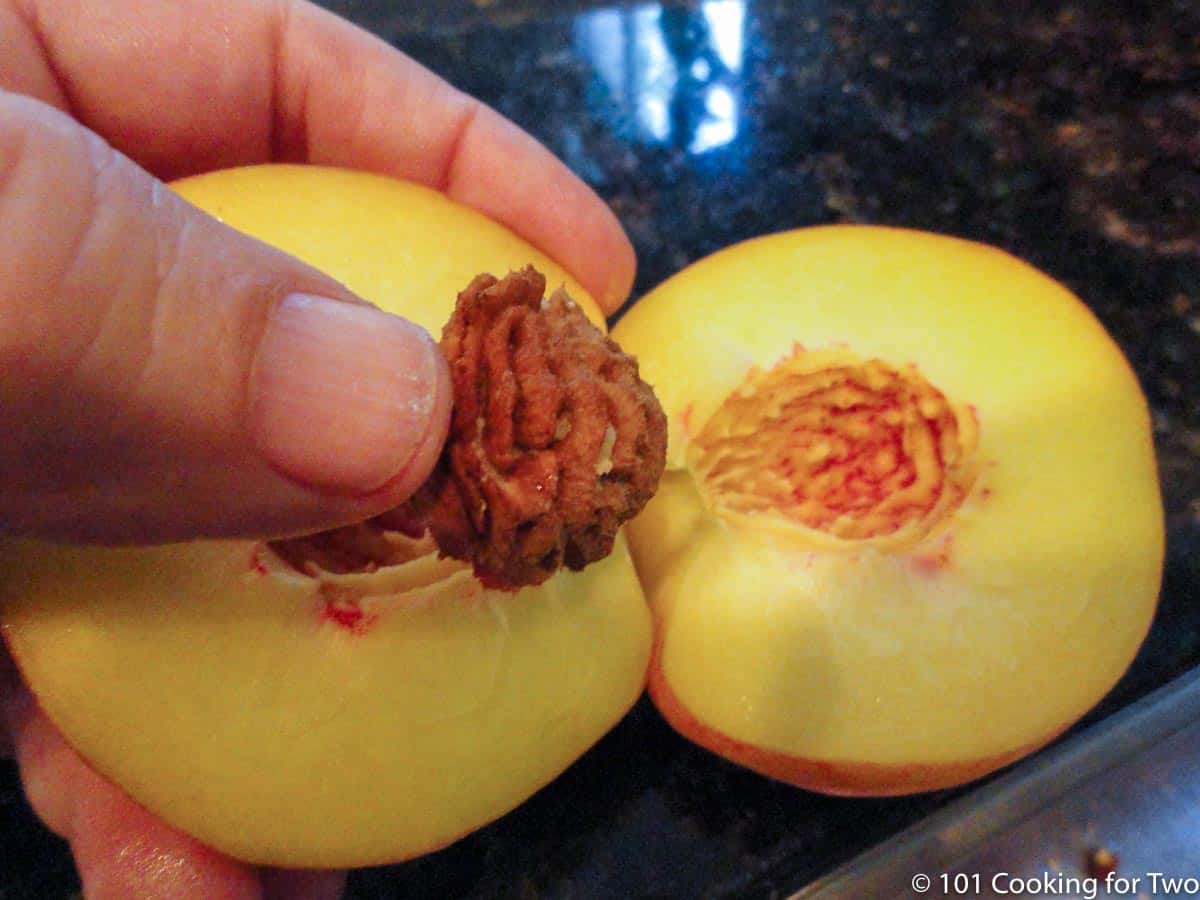 removing peach pit from a peach half.