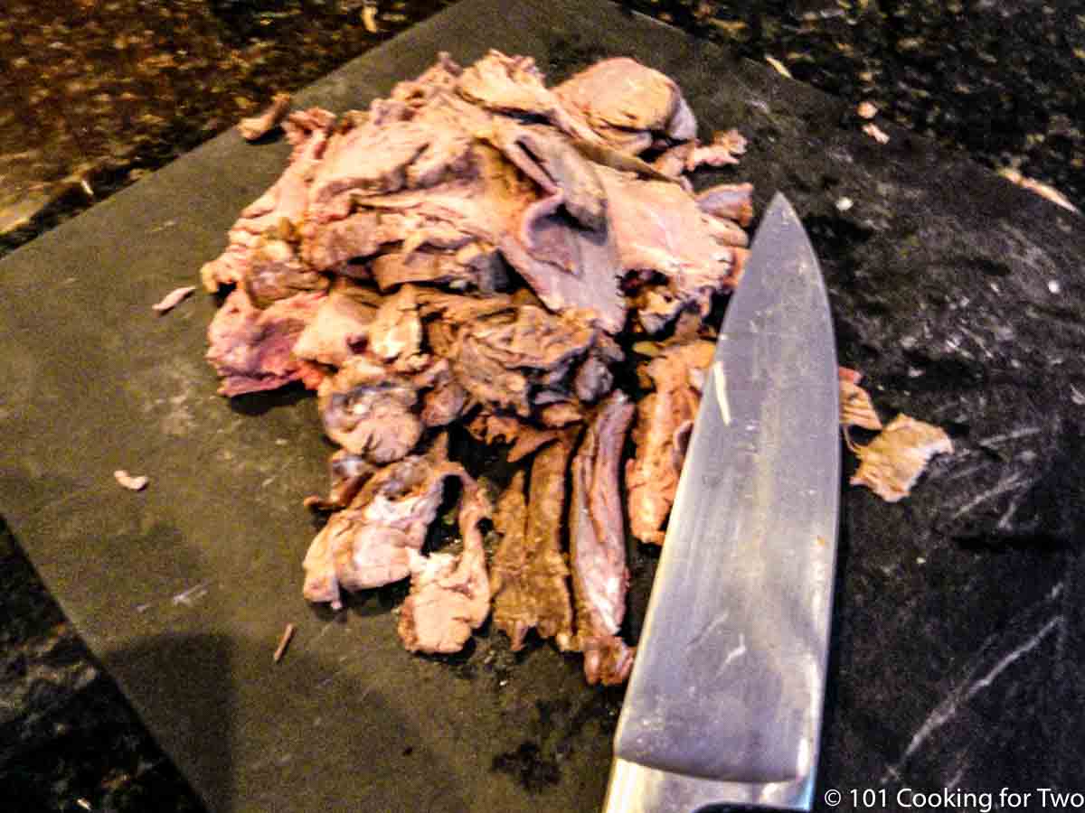 cut up beef on a black board.