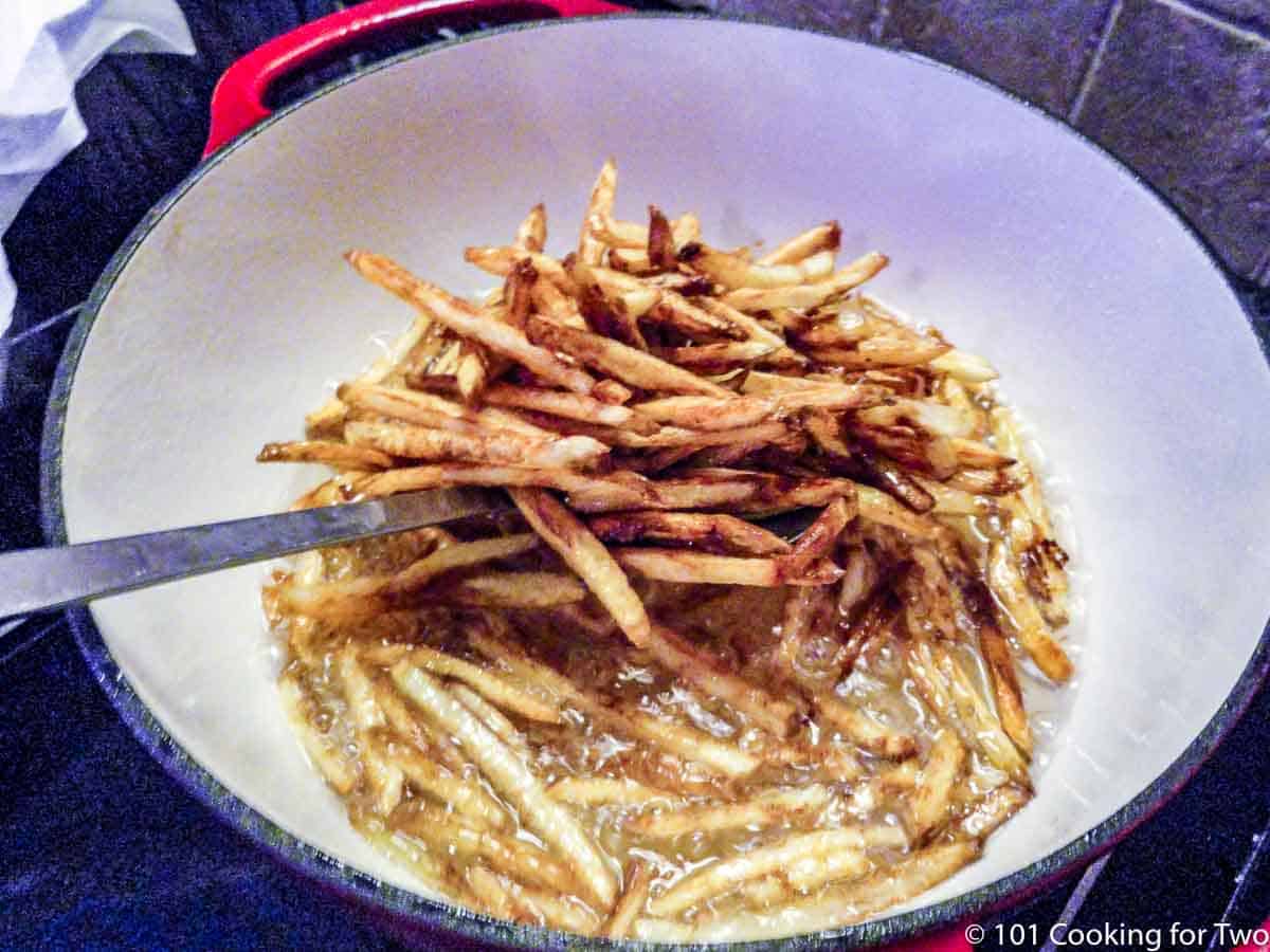 scooping fries out of oil