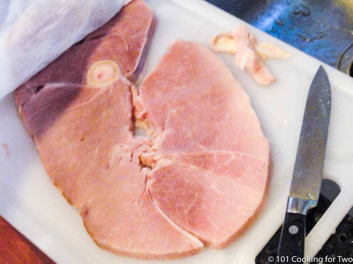 slice of ham trimmed of fat on a white board.