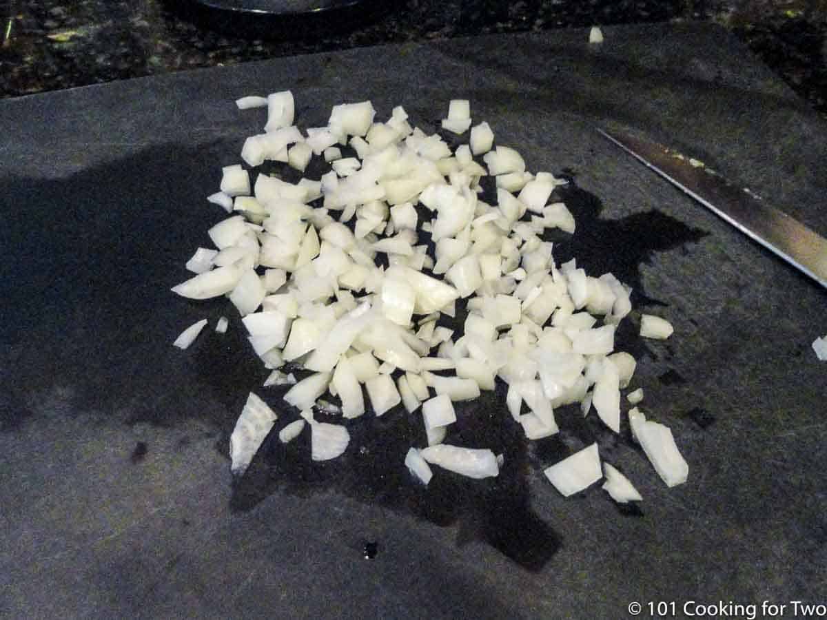 chopped onion on black board.