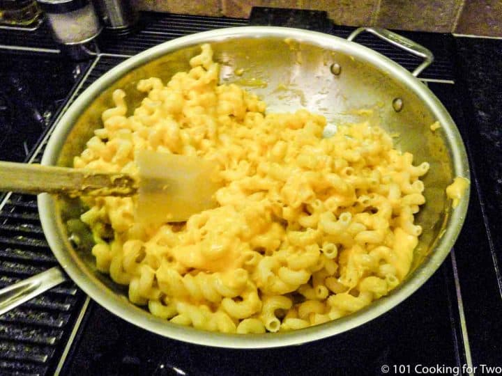 mixing sauce and cooked pasta in large pan
