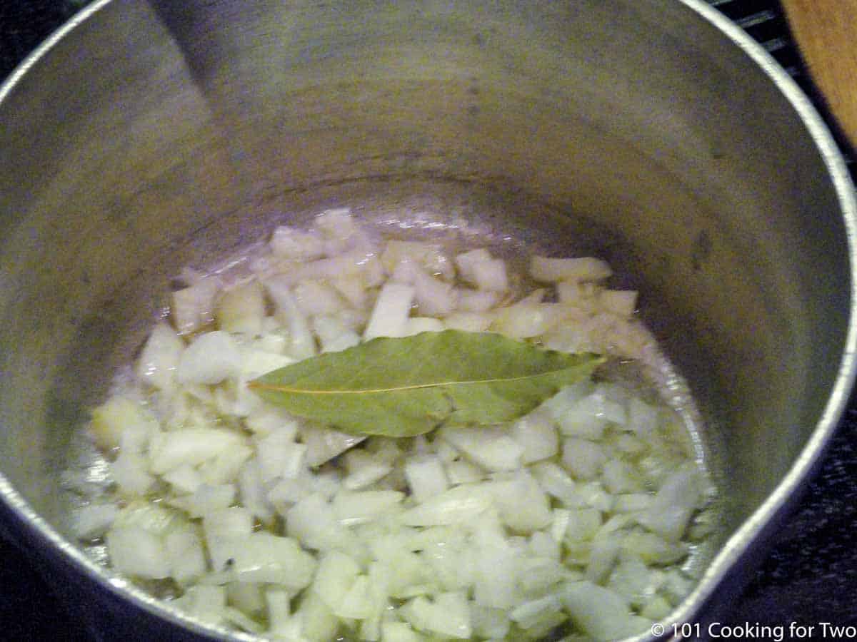onion in saucepan with bqy leaf