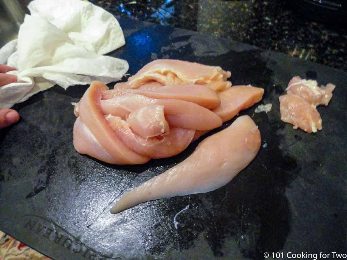 trimmed chicken on black board.