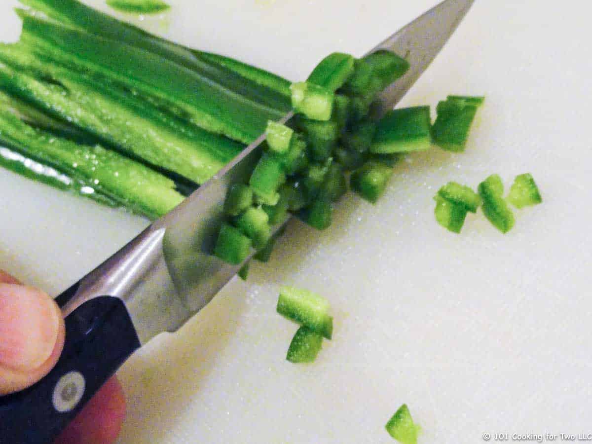 minicing a jalapeno on black board.