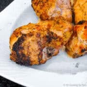 Grilled split chicken breasts on a plate.