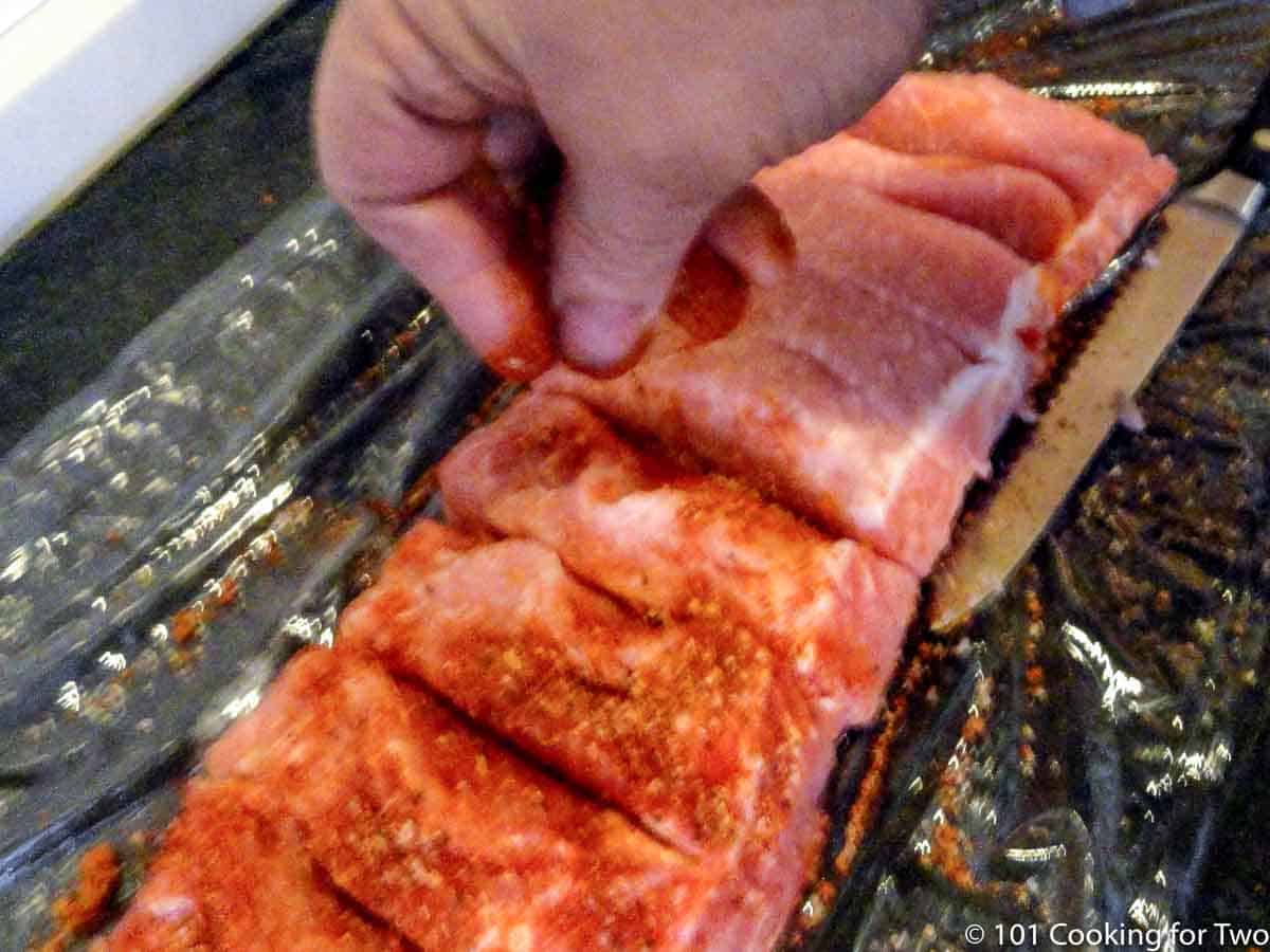 adding rub to boneless ribs