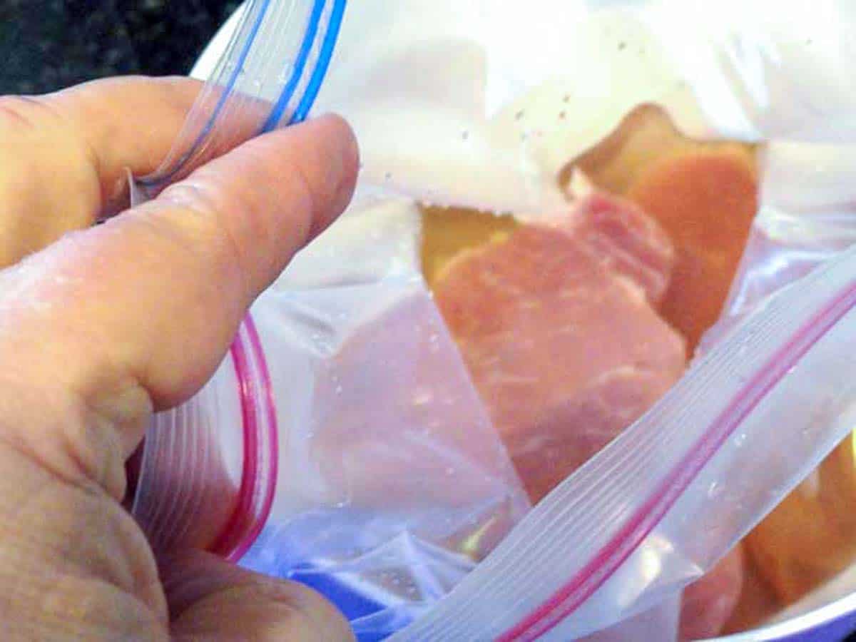 raw pork chops in bag with brine