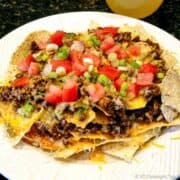 taco meat on nachos on a white plate