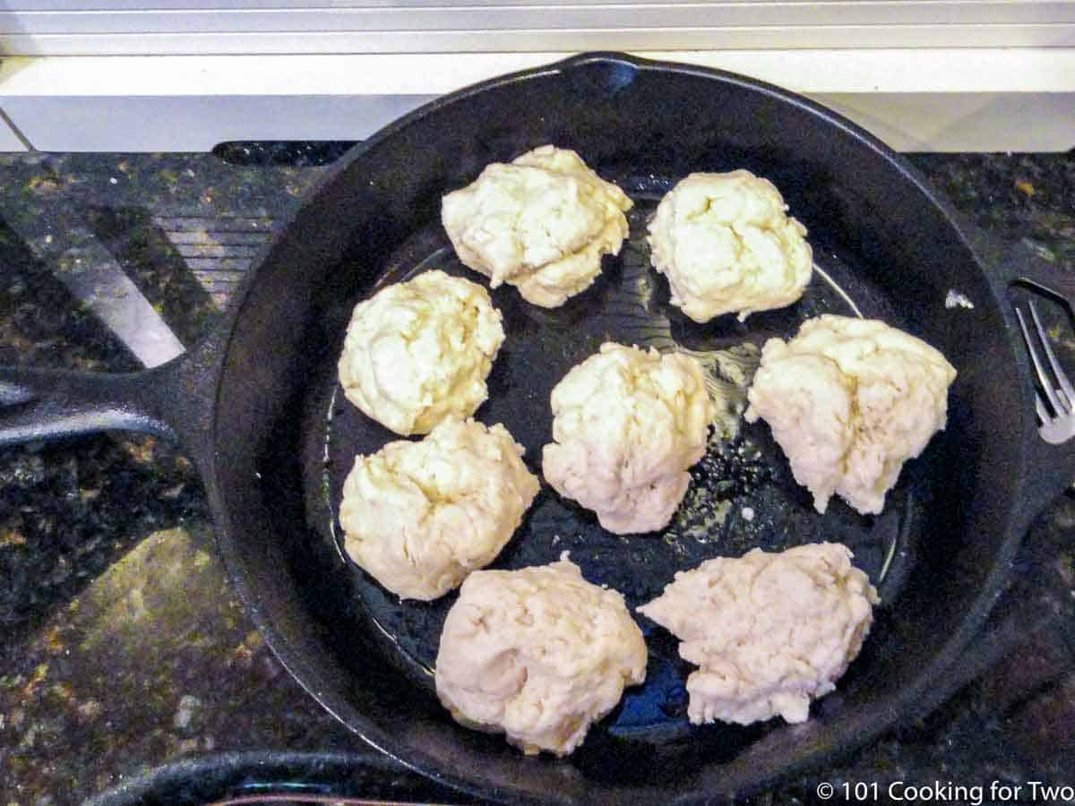 eight raw biscuits in a cast iron pan.