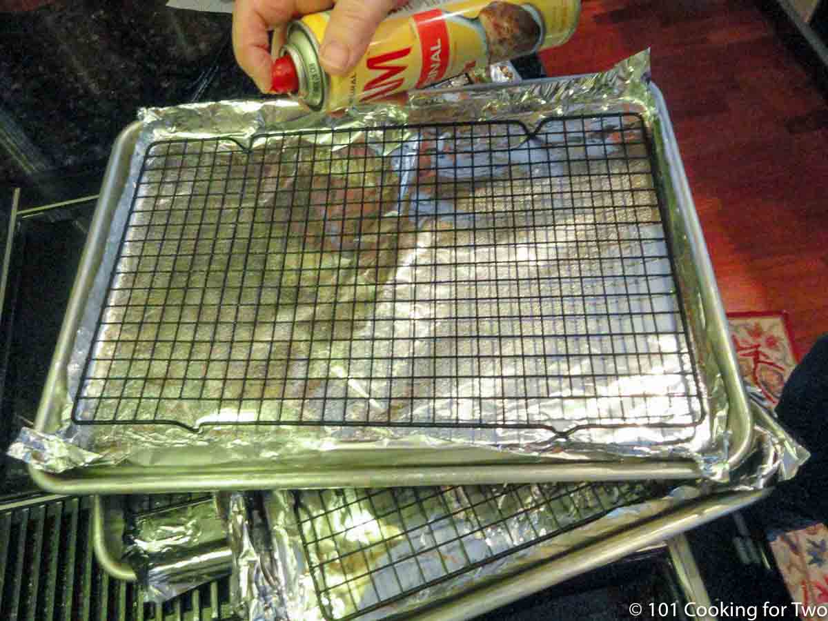 Spraying trays with racks with PAM.