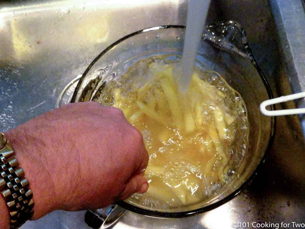 rinsing fries under running water