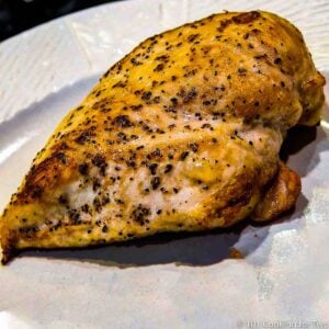 a close up picture of a cooked chicken breast on a white plate