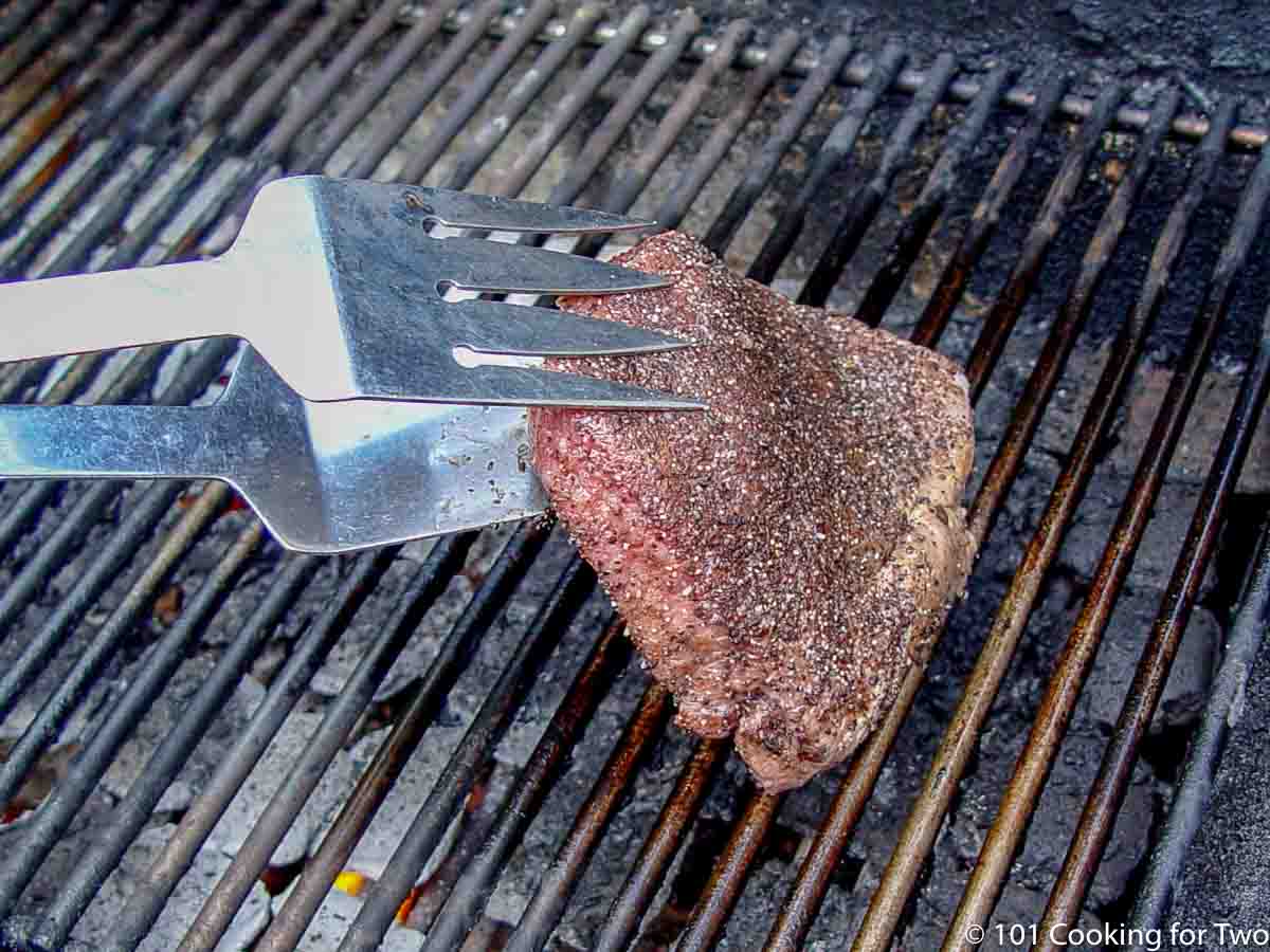 placing sirloin on grill