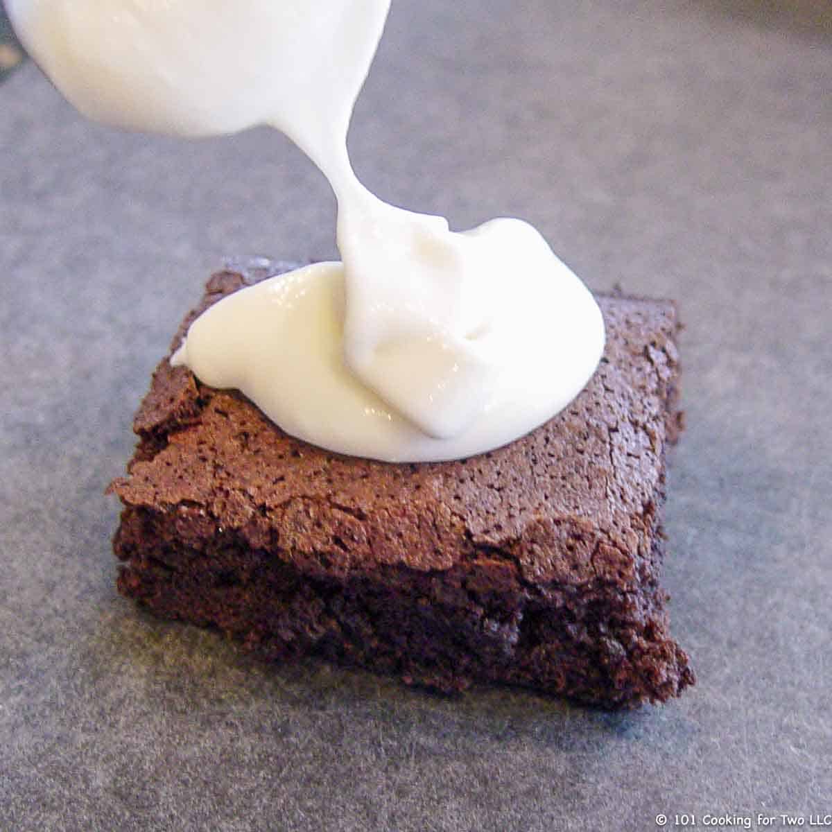 adding frosting to brownie