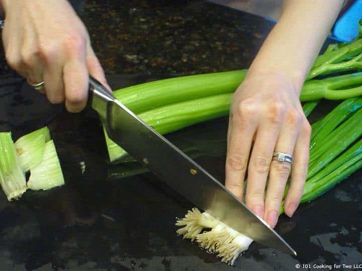 trimming onion and celery on black board.