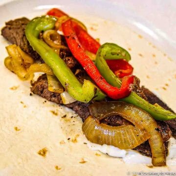 Steak Fajitas on tortilla and white plate