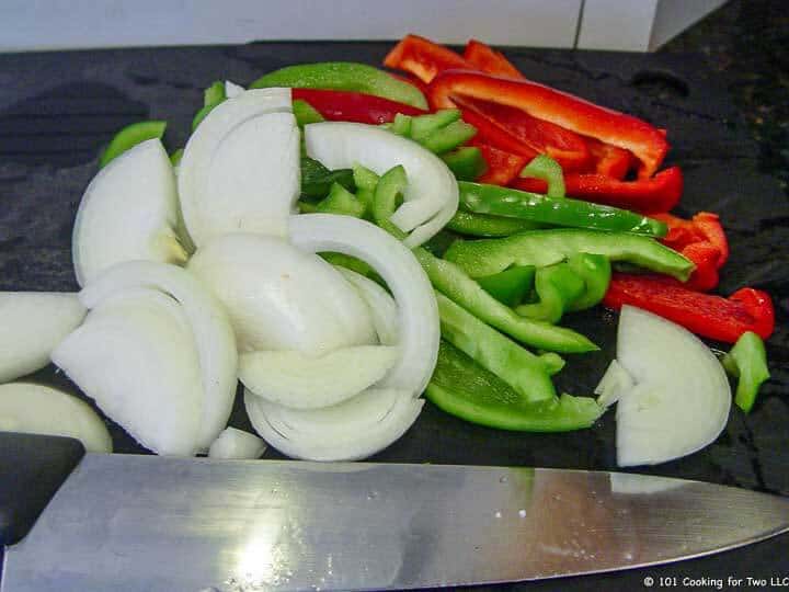 sliced peppers and onion with knife.