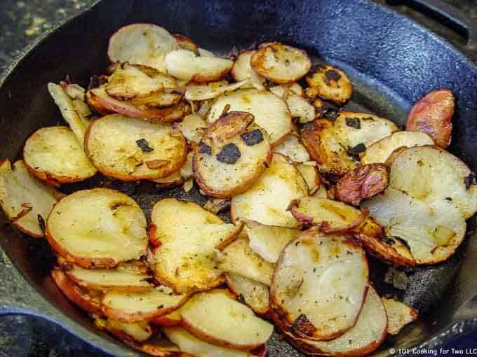 image of potato slices cooking in a black cast iron pan