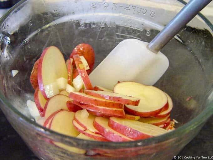 Mixing oil into onion and potato slices