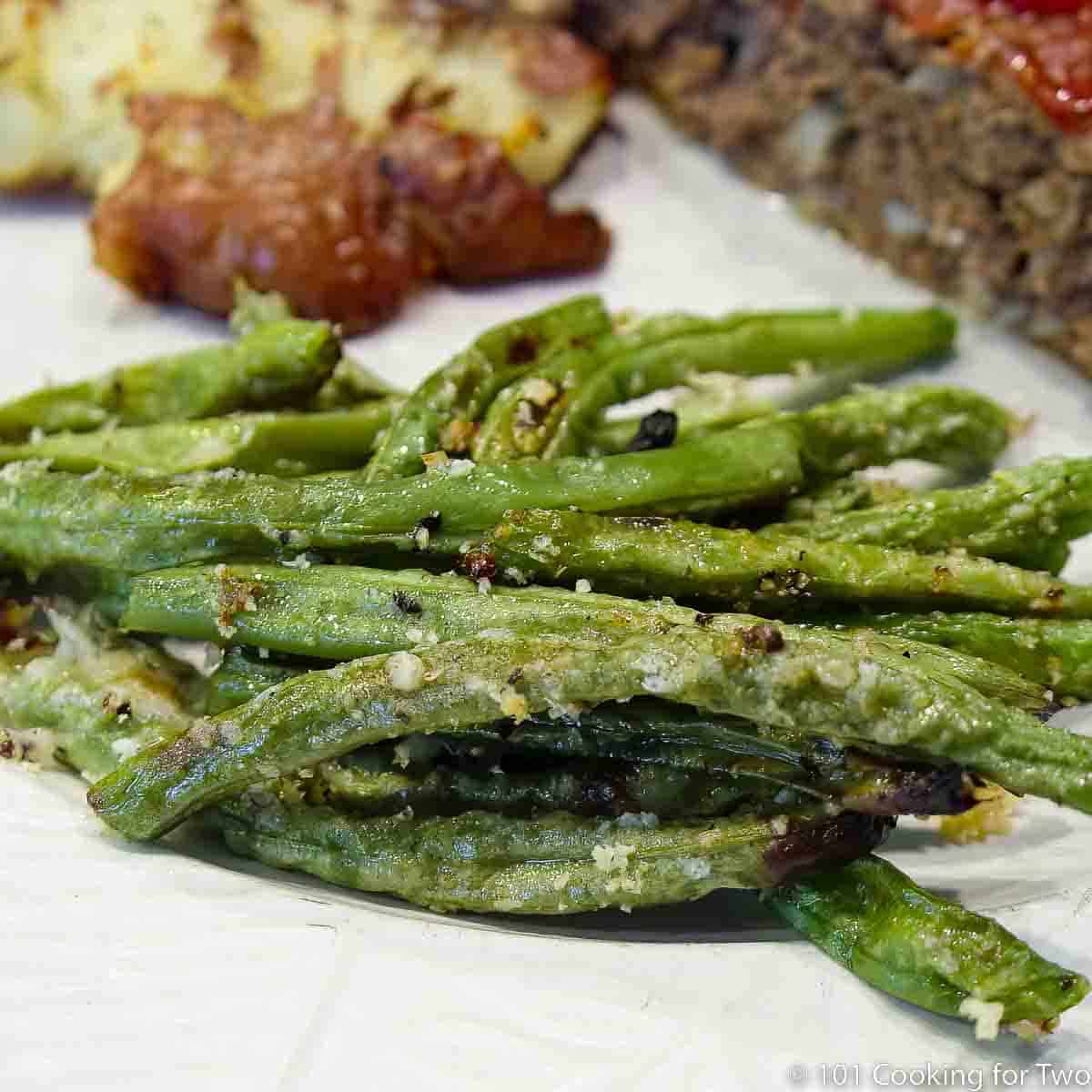 Parmesan green beans on white plate