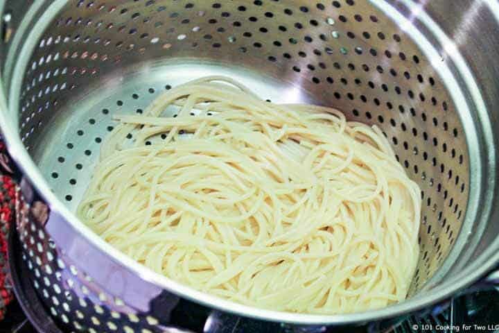 cooked spaghetti draining.