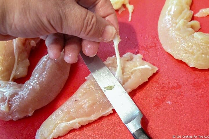 trimming tendon from a chicken tenderloin