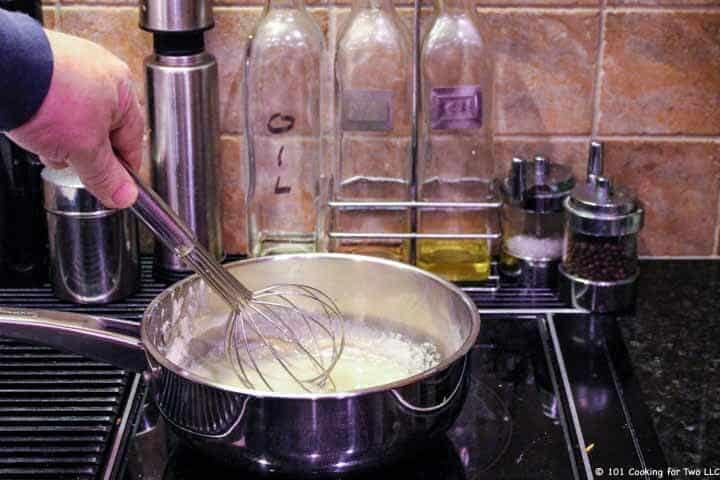 whisking sauce in pan.