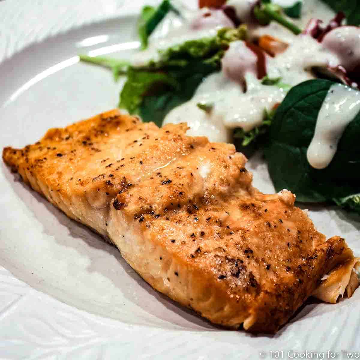 Salmon with salad on light gray plate