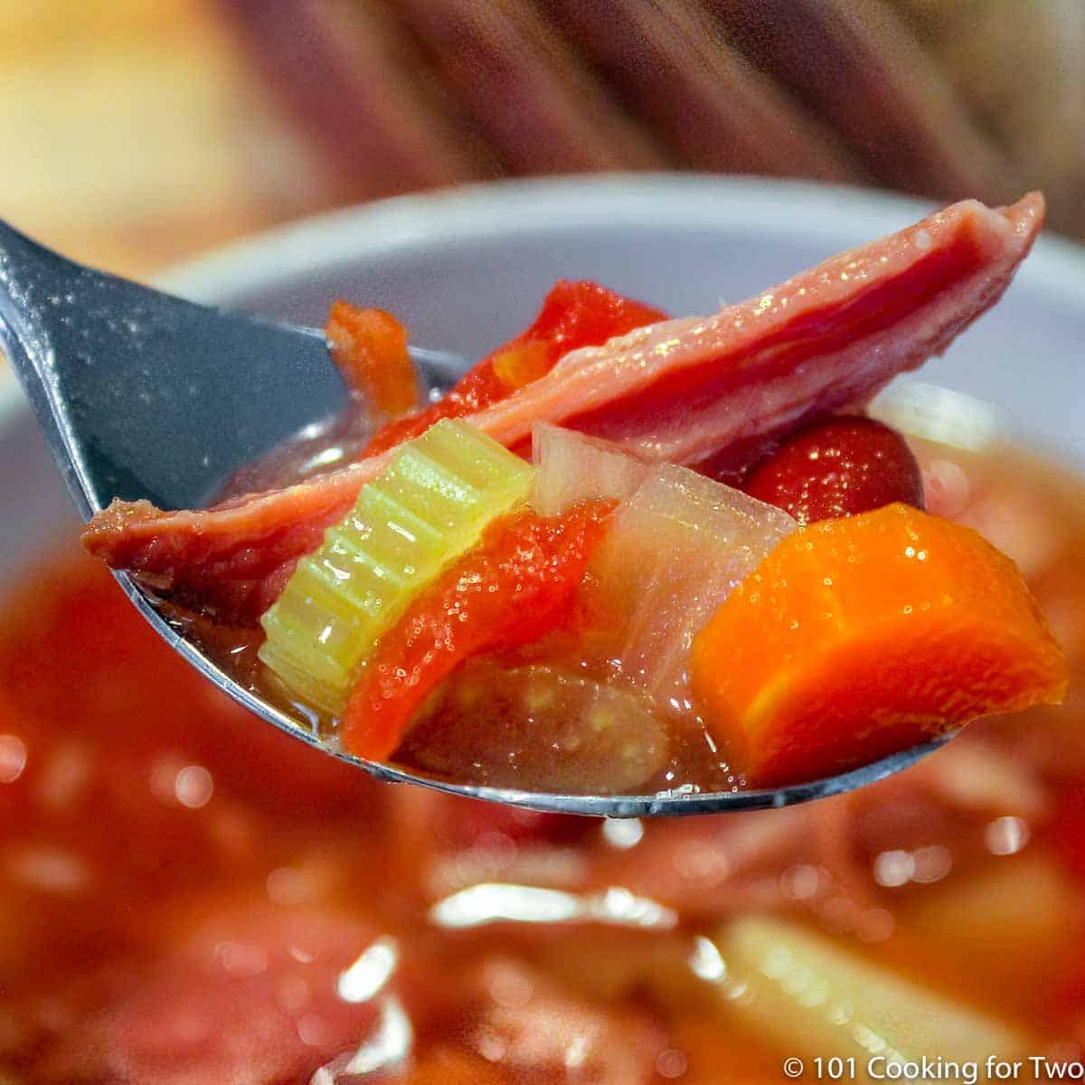 close up image of a tablespoon of ham bone vegetable soup