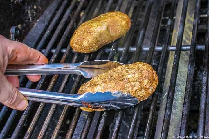 placing potatoes on grill with tongs.