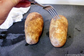 poking a potato with a fork on a black board