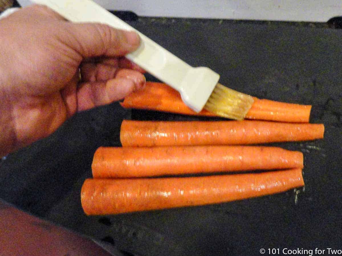 Brushing carrots with oil.
