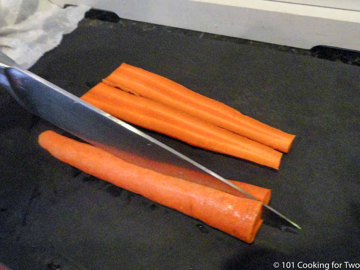 cutting carrots in half with knife.