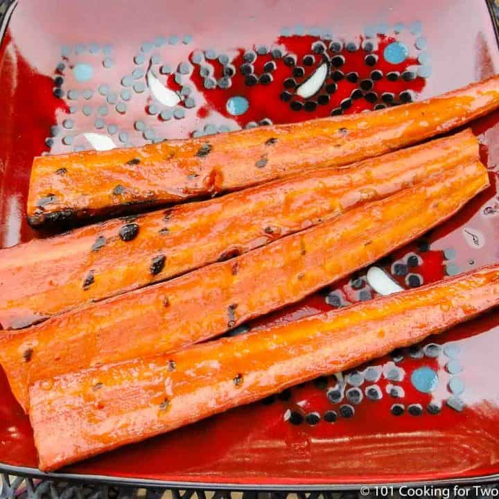grilled carrots on a red plate