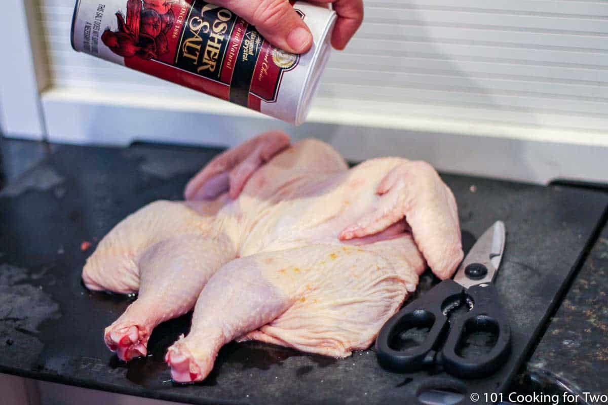 Seasoning butterfied chcken with salt.