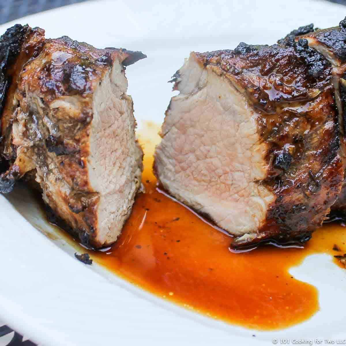 A cut pork tenderloin on a white plate.