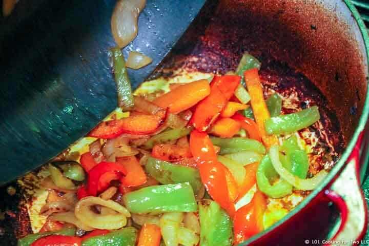 adding cooked veggies to dirty Dutch oven.