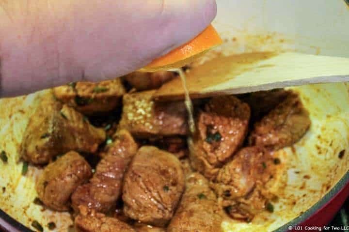 adding orange juice to browned meat.